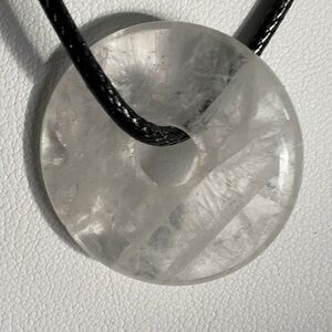 Clear Quartzdoughnut wrapped around a black rope 18”